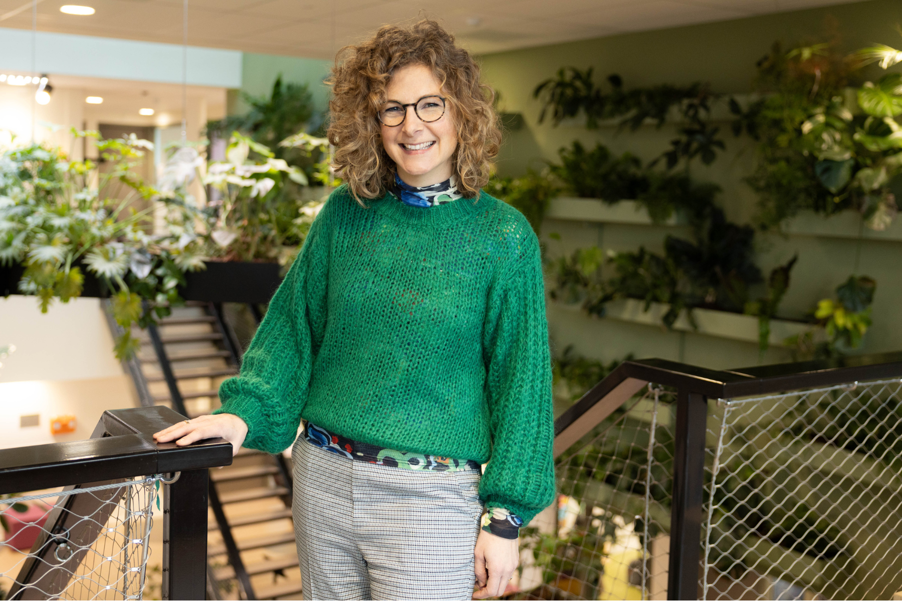 Gerrie stoffer, student master gezond gedrag en leefomgeving, staat lachend aan de balustrade. 