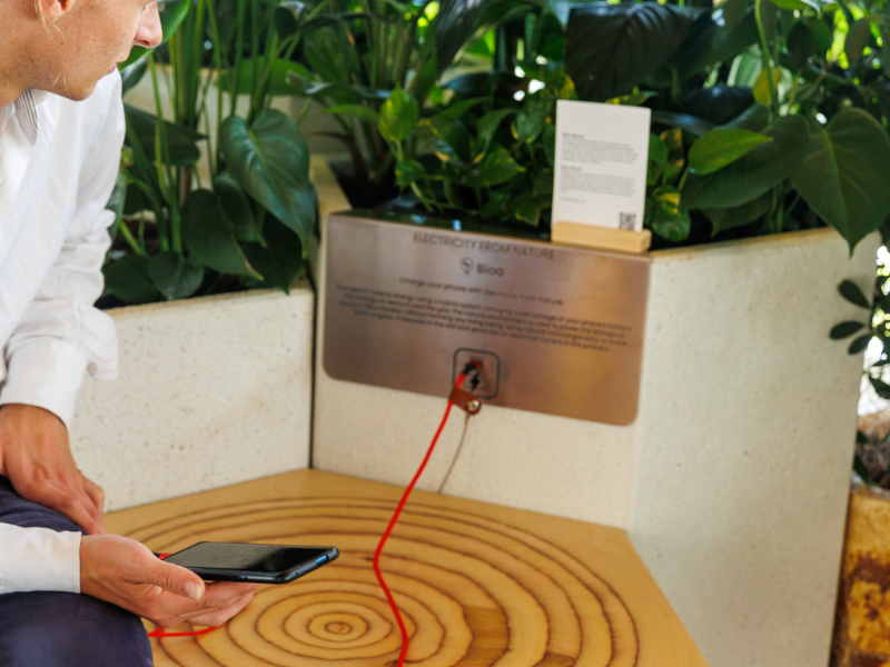 Student laadt zijn telefoon op via een groen bio energie punt