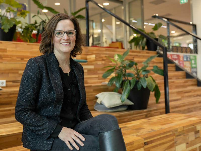 fleur is master student gezond gedrag en leefomgeving en kijkt lachend in de camera