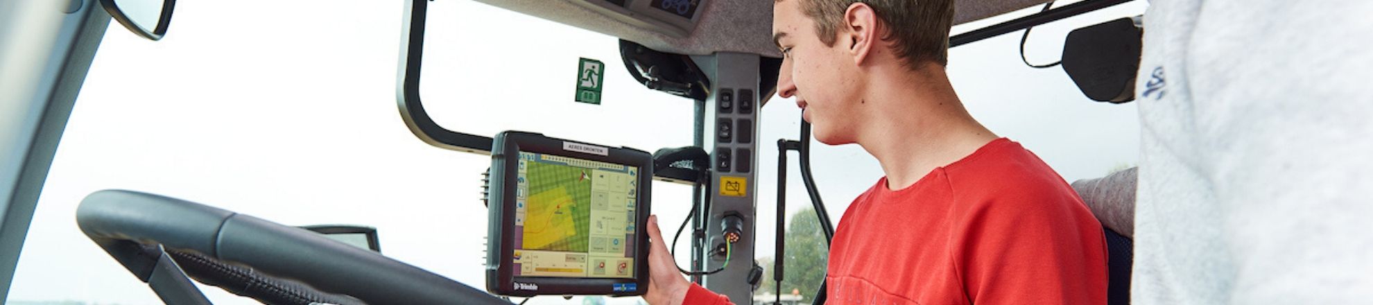 Student zit in trekker en krijgt les over smart farming met de nieuwste techniek