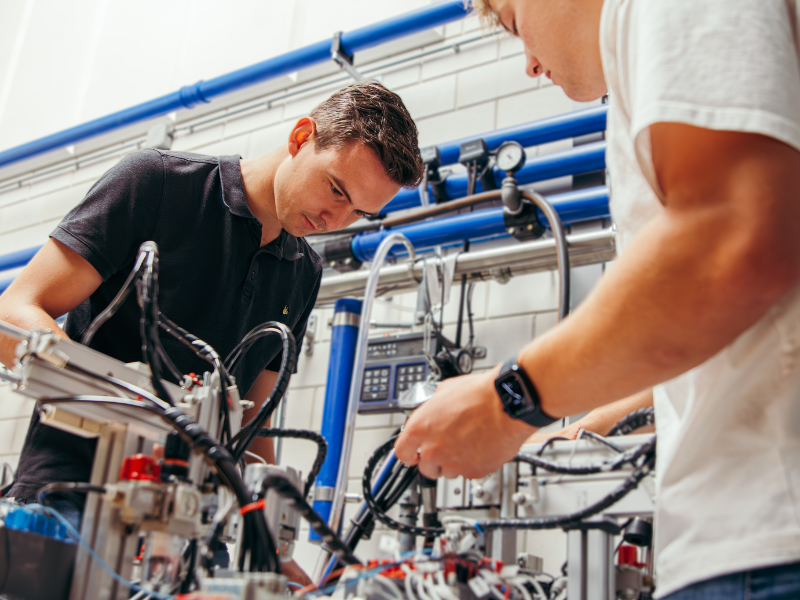 Studenten techniek werken aan een technische opstelling met elektra draden