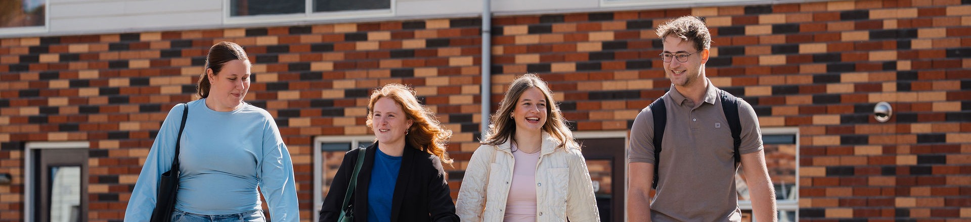 3 jongens en een meisje lopen 
