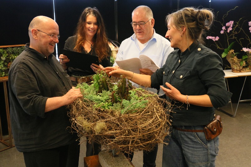 Docenten beoordelen een plantenarragement van een eerstejaars student Plantaardige vormgeving