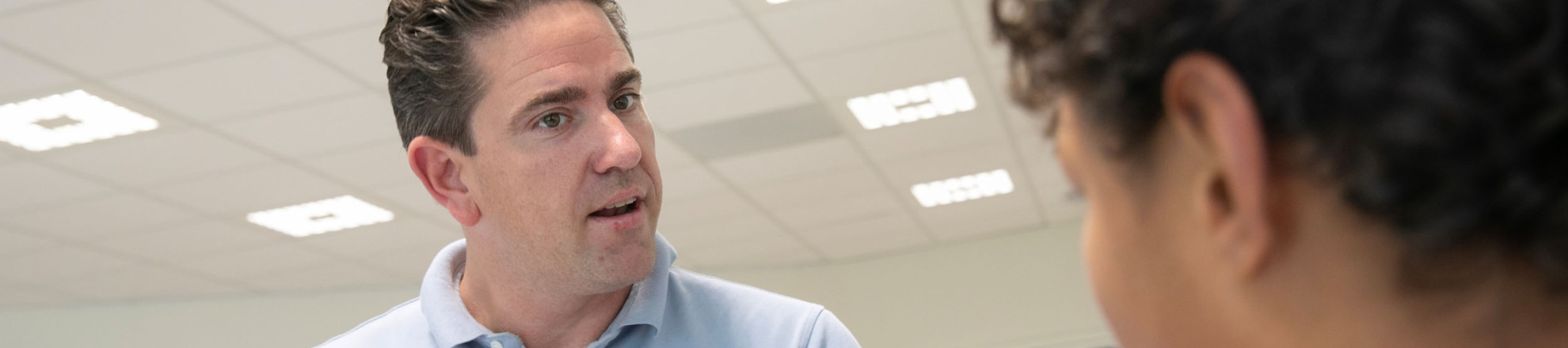 Patrick, student Docent en kennismanager Dienstverlening en producten praat tegen een andere student