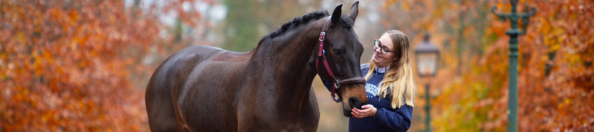 Student Rianne Prins staat met haar paard in het bos