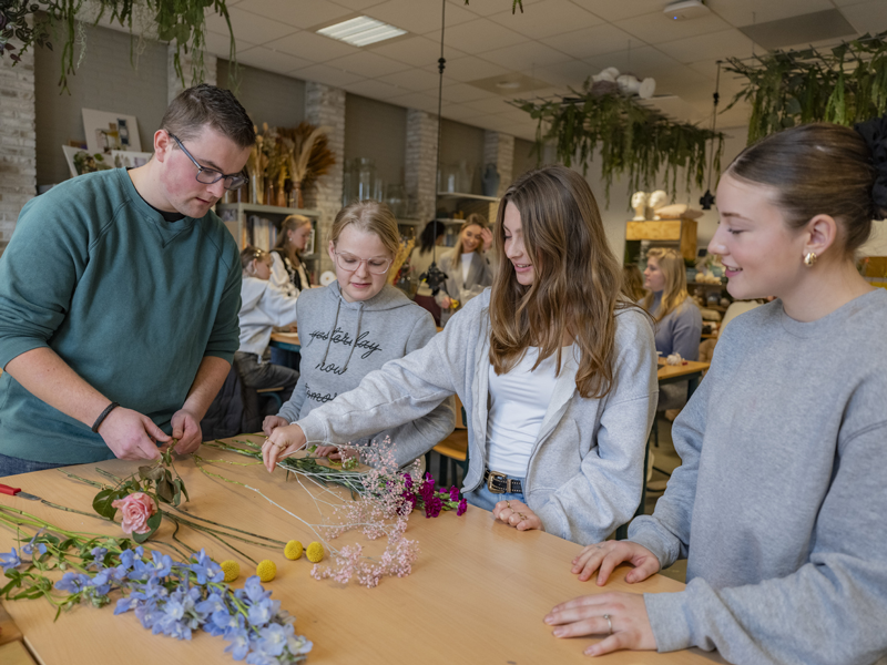 Docent en kennismanager Groen legt uit aan studenten met bloemen