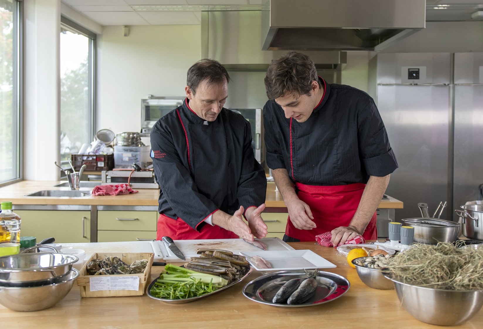 twee mannen bereiden eten in een keuken