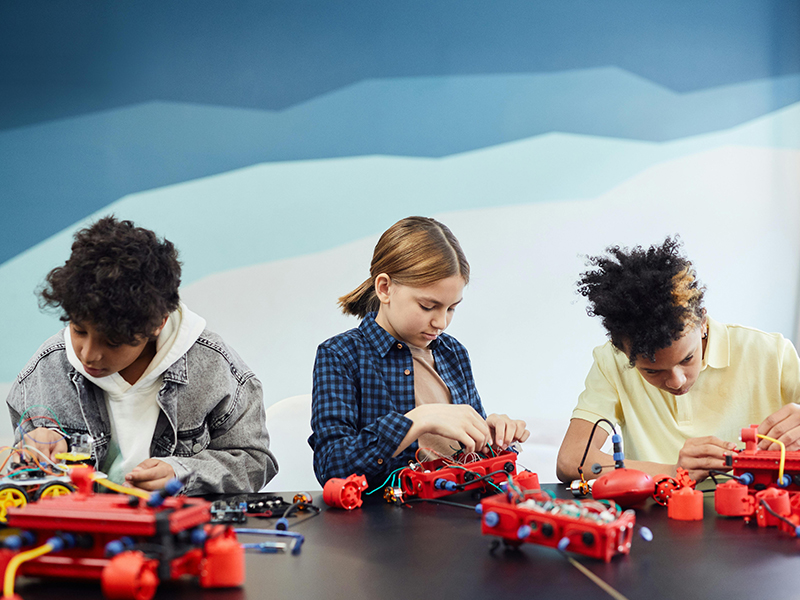 3 kinderen die aan het spelen zijn met technisch speelgoed