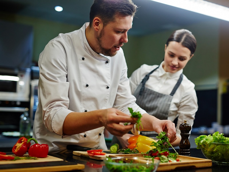 Consumptieve techniek twee koks in keuken salade