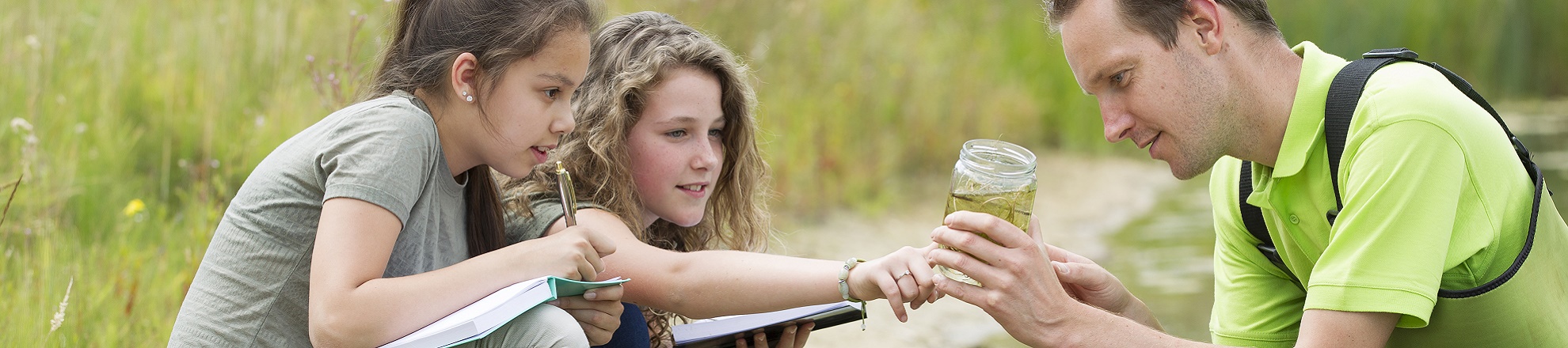 Groene sector docent met jonge leerlingen buiten bij water