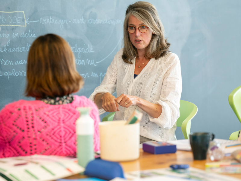 Vrouw geeft uitleg aan andere vrouw