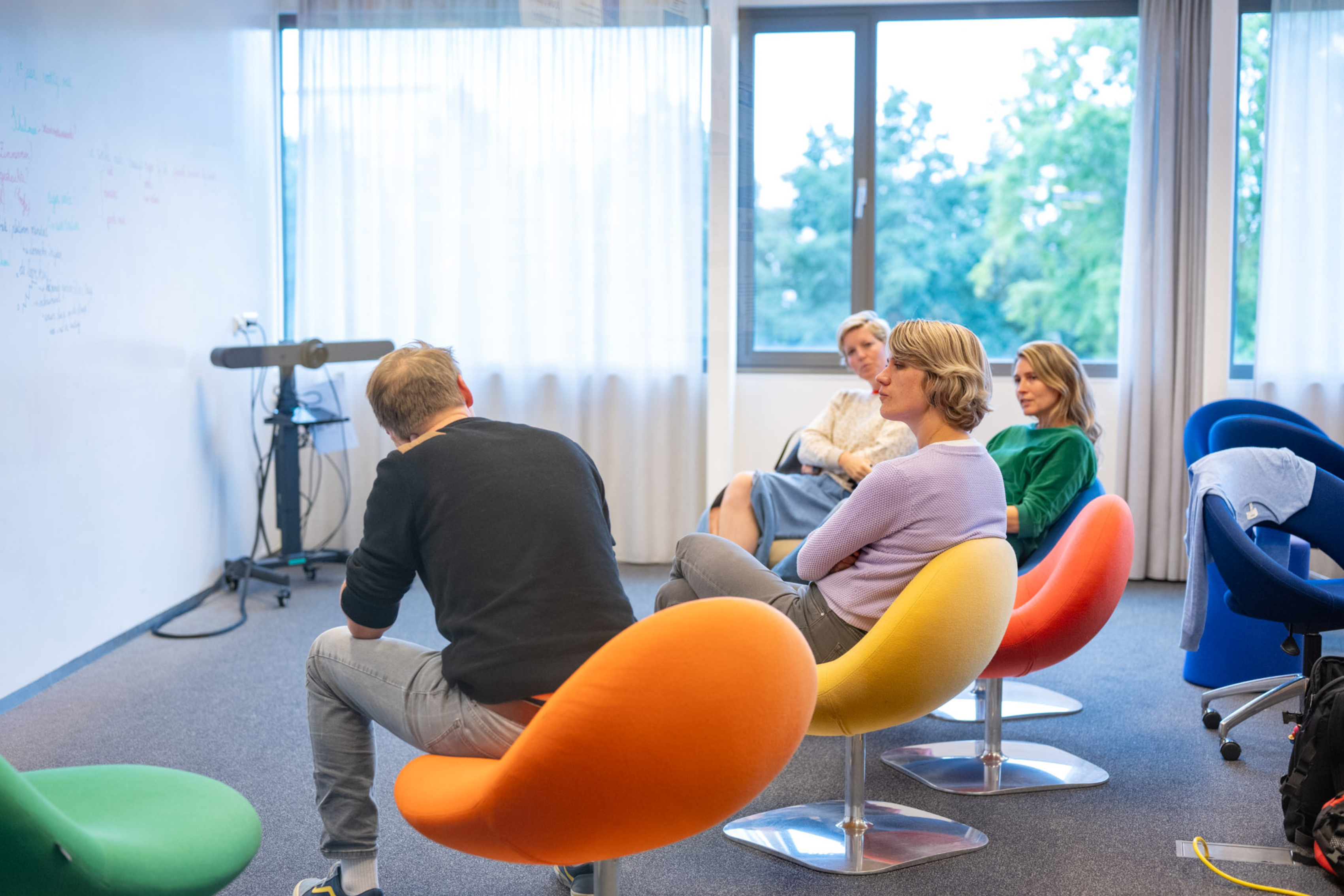 Studenten zitten in stoelen te overleggen